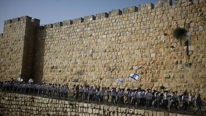 Youths wave Israeli flags during a parade marking "Jerusalem Day" amid Israeli-Palestinian tension at Jerusalem's Old City, May 10, 2021.