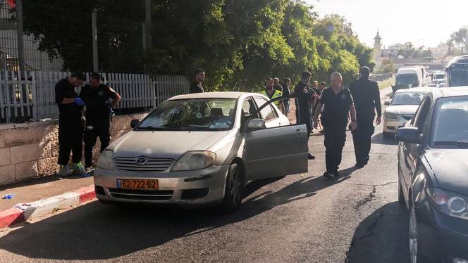 Israeli police work next to the car at the scene of a shooting incident in East Jerusalem.