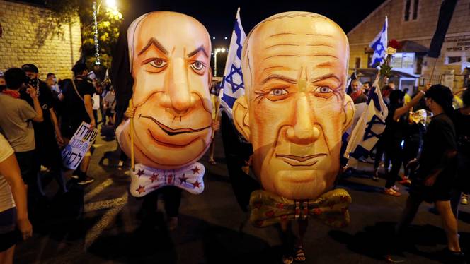 Demonstrators wear masks depicting Israeli Prime Minister Benjamin Netanyahu and Israel's Alternate Prime Minister and Defence Minister Benny Gantz during a protest in Jerusalem, August 8, 2020.
