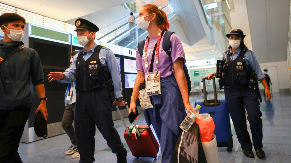 Belarusian athlete Krystsina Tsimanouskaya is escorted by police officers at Haneda international airport in Tokyo, Japan August 1, 2021.
