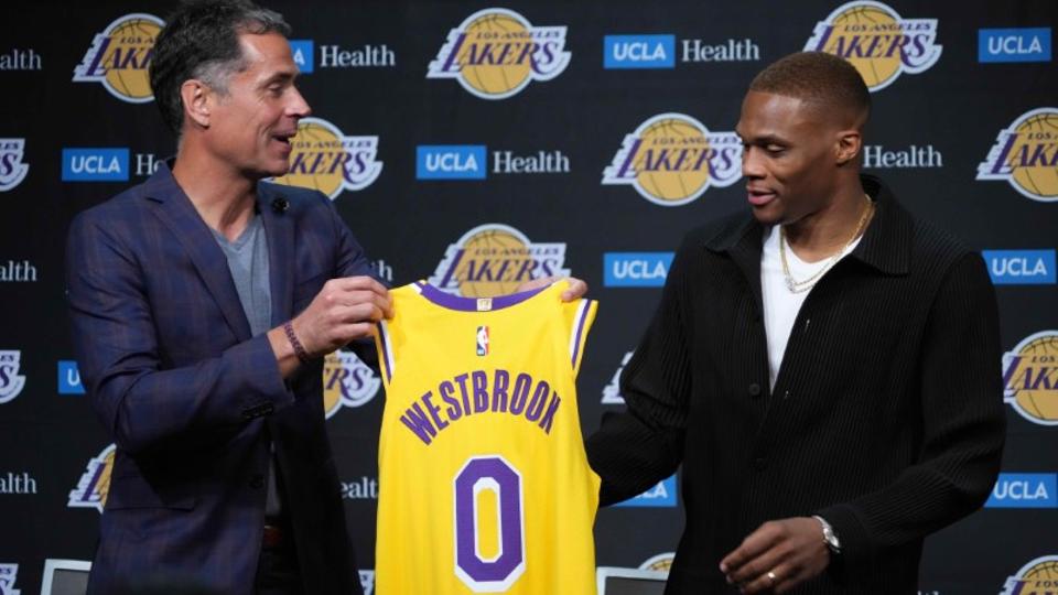 Aug 10, 2021; Los Angeles, California, USA; Los Angeles Lakers general manager Rob Pelinka (left) presents Russell Westbrook with a jersey at press conference at Staples Center.