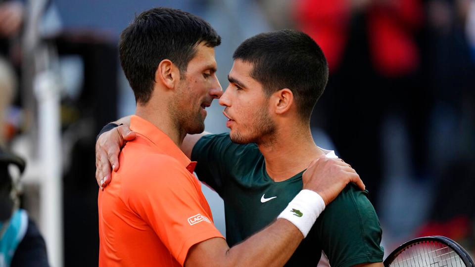 Novak Djokovic, left, shakes hands with Carlos Alcaraz at the end of a men's semifinal at the Mutua Madrid Open tennis tournament in Madrid, Spain, Saturday, May 7, 2022. Alcaraz won 6-7 (5-7), 7-5, 7-6 (7-5).