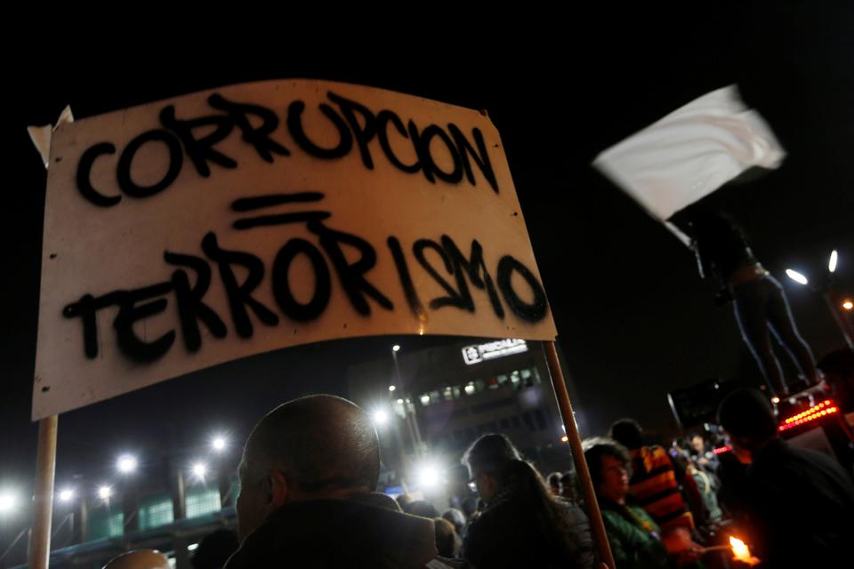 A protester holds a sign that reads