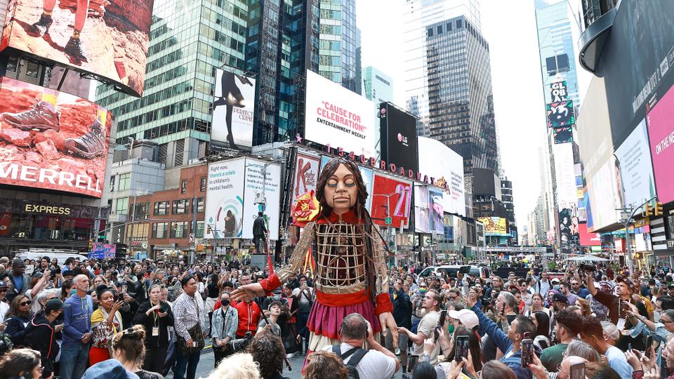 Broadway performers and about 200 New York City students serenade Amal to calm her in bustling Times Square.