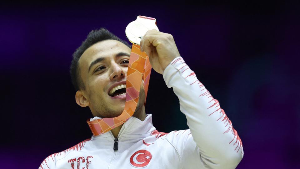 Turkey's Adem Asil celebrates with medal on the podium after winning gold at the men's apparatus final rings.