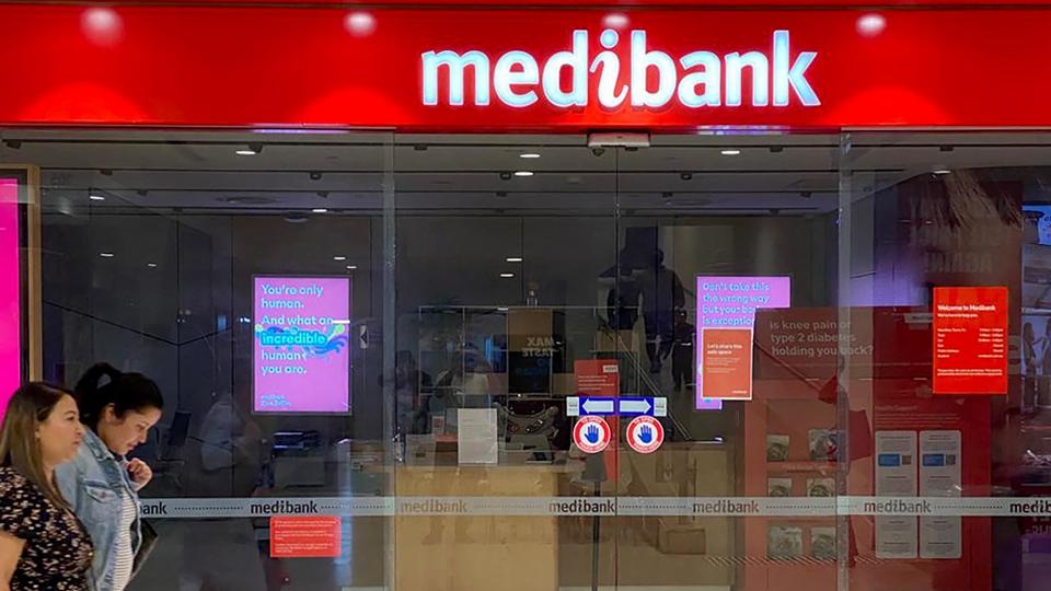 People walk past a shop front for Australia's largest health insurance company Medibank, in Sydney on November 11, 2022. Russian hackers carried out a cyberattack on Medibank that breached the data of 9.7 million people, including the country's prime minister, police said 11 November.