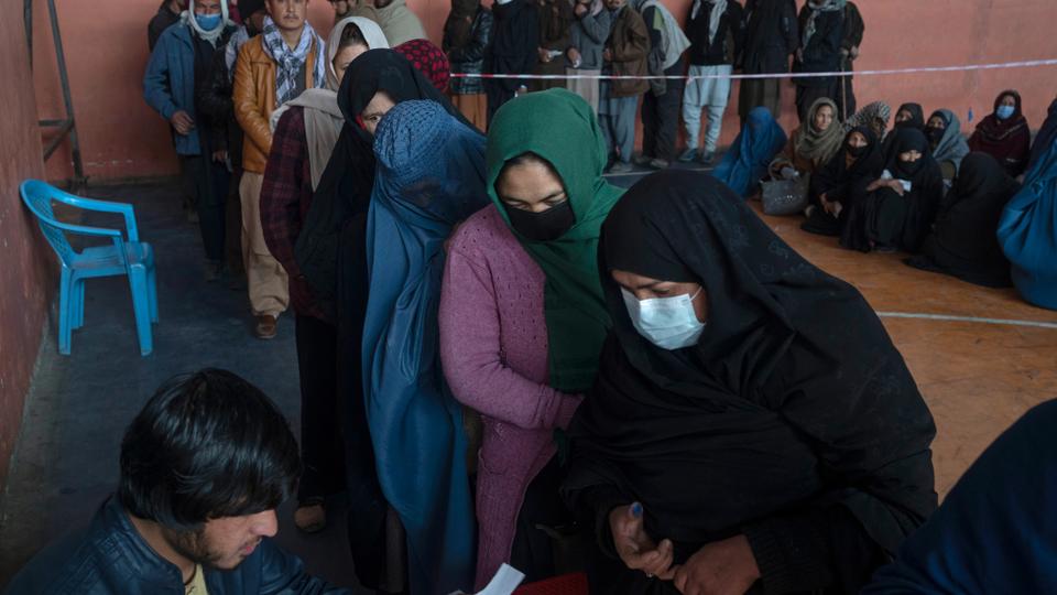 People wait to receive cash at a money distribution organised by the World Food Program in Kabul, Afghanistan.