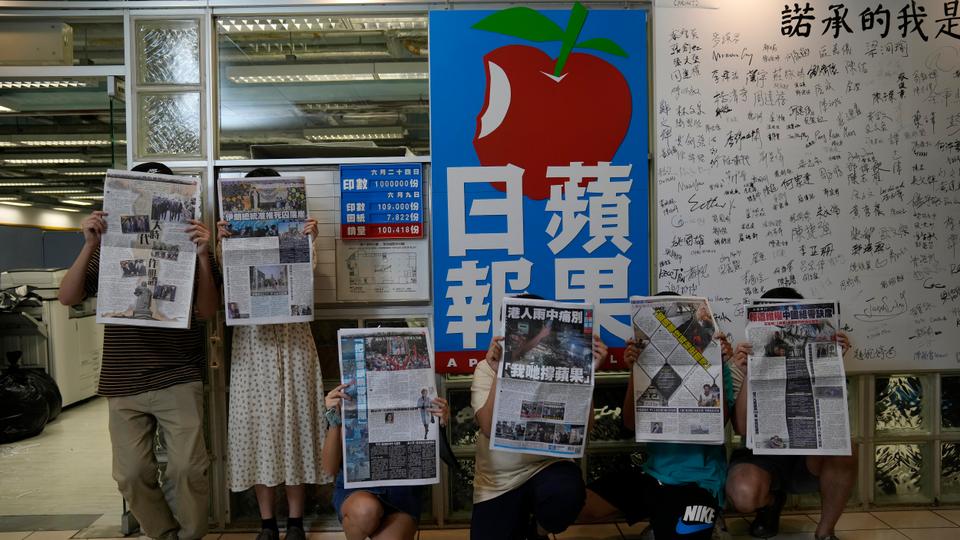 Staff members of Apple Daily pose at the headquarters in Hong Kong on June 23, 2021. - FILE