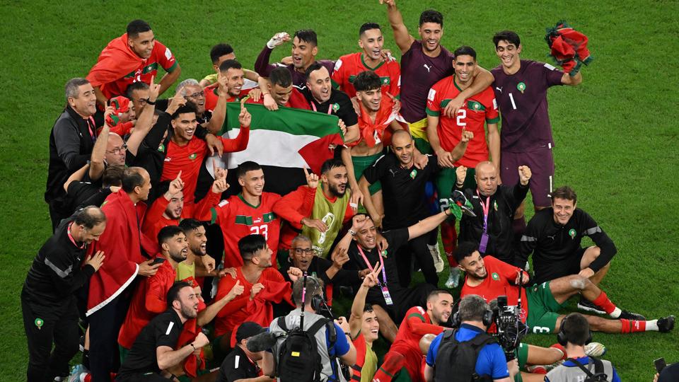 Morocco players celebrate their win over Spain with the Palestinian flag.
