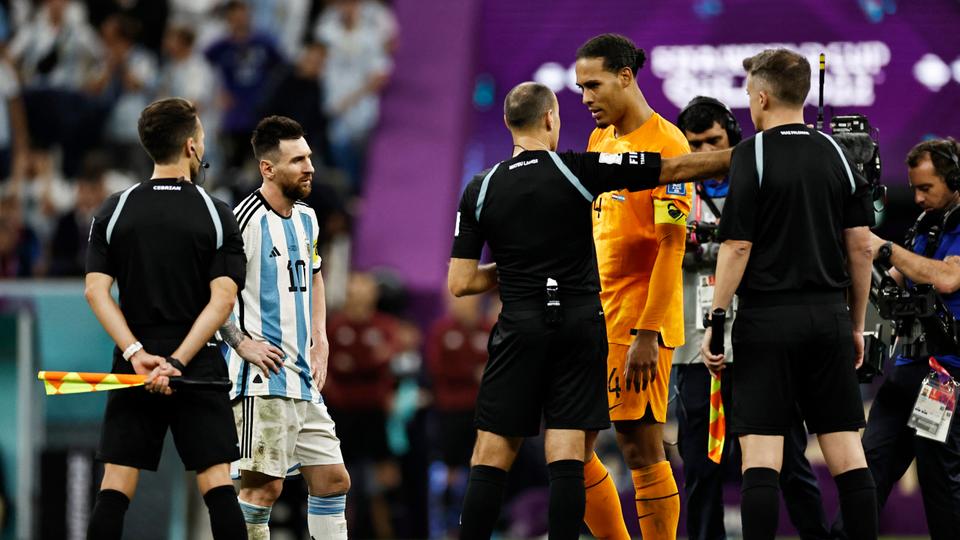 Netherlands' Virgil van Dijk and Argentina's Lionel Messi speak with referee Antonio Mateu Lahoz before the penalty shootout.