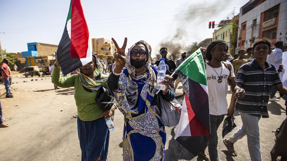 In this photo, Sudanese citizens are seen holding banners and flags as they walk to the Presidential Palace in Khartoum, Sudan on December 19, 2022.