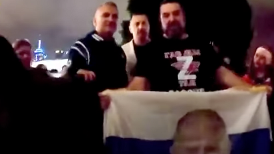 Video posted to pro-Russian Australian YouTube account shows Srdjan posing with a man holding a Russian flag with Vladimir Putin's face on it.
