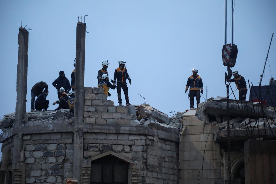 Rescuers work at the site of a damaged building, following an earthquake, in rebel-held Azaz