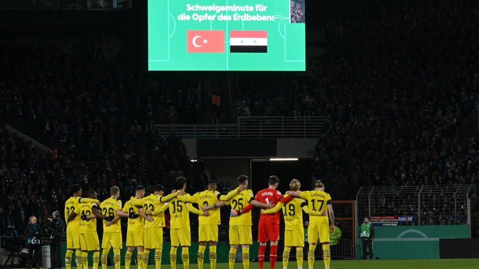 Borussia Dortmund team is pictured as it stands for a minute of silence in honour of quake victims in Türkiye and Syria.