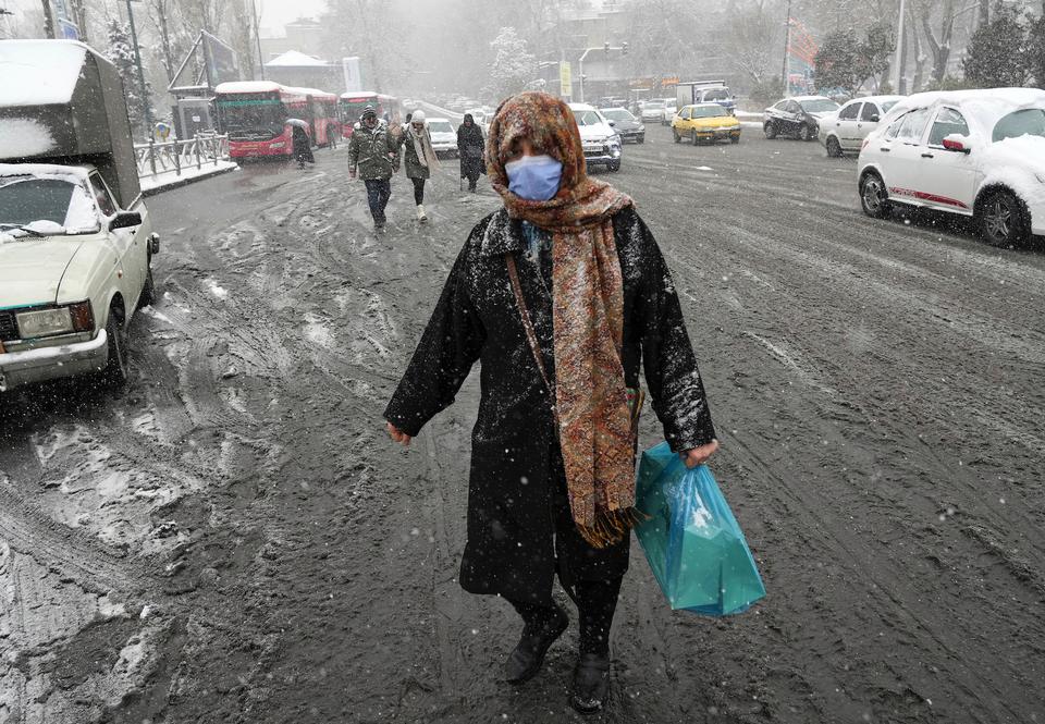 A woman crosses the Tajrish Square area in northern Tehran, Iran, January 15, 2023. The rare snowfall and cold weather that had led to a shortage of natural gas for households and factories, has also forced the government to close schools as well as government offices and private businesses in parts of Iran.