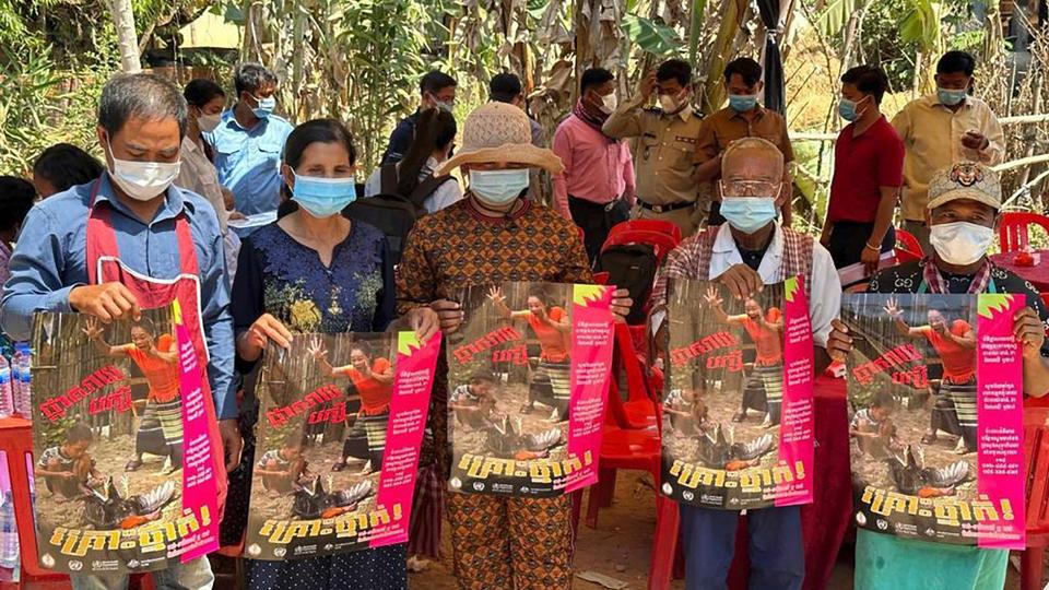 Cambodia villagers hold posters to spread awareness of H5N1 virus threats as health experts try to educate them to take care of their health, in Prey Veng eastern province Cambodia,