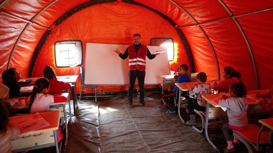 Students receive education in the class of Mehmetcik tent school set up at the tent city in Serinyol Neighbourhood in Hatay.
