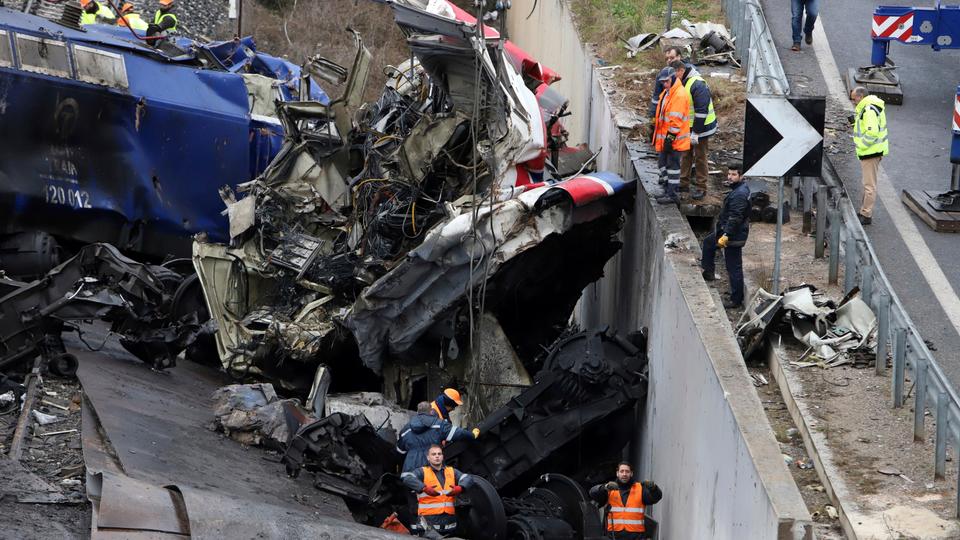 Workers supported by a crane try to remove debris from the rail lines after a collision in Tempe, about 376 kilometres (235 miles) north of Athens, near Larissa city, Greece, March 2, 2023.