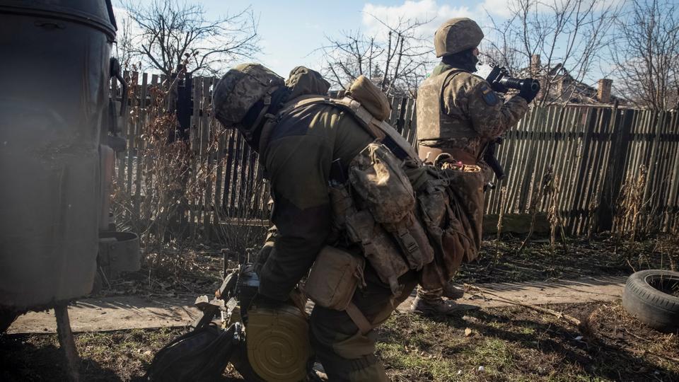 Ukrainian servicemen prepare an automatic grenade launcher to fire in the front line city of Bakhmut on March 3, 2023.