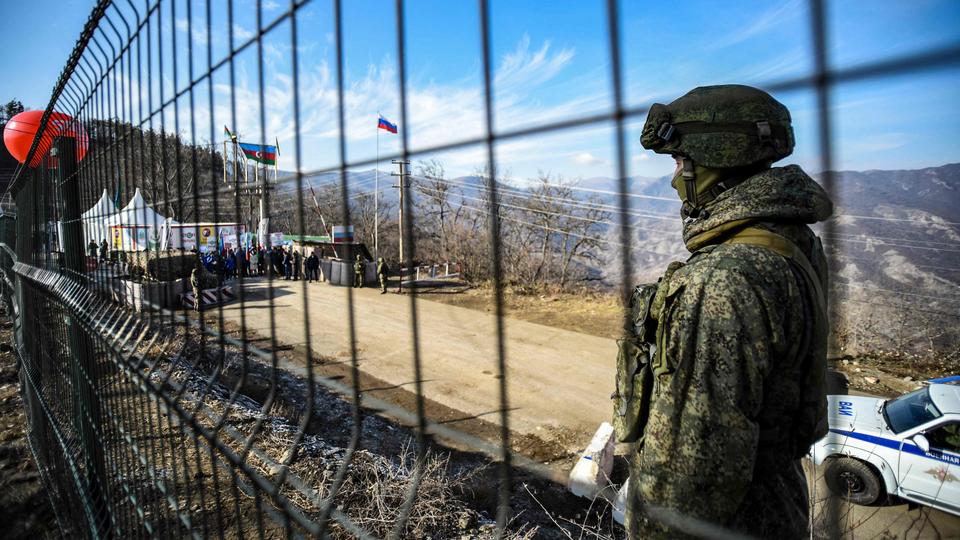 A Russian peacekeeper guards the Lachin corridor, the Karabakh region's only land link with Armenia, as Azerbaijani environmental activists protest against illegal mining, on December 27, 2022.