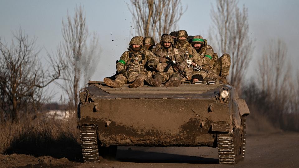 Ukrainian servicemen sit on a BMP military vehicle as they move towards Bakhmut in the region of Donbas, on March 13, 2023.