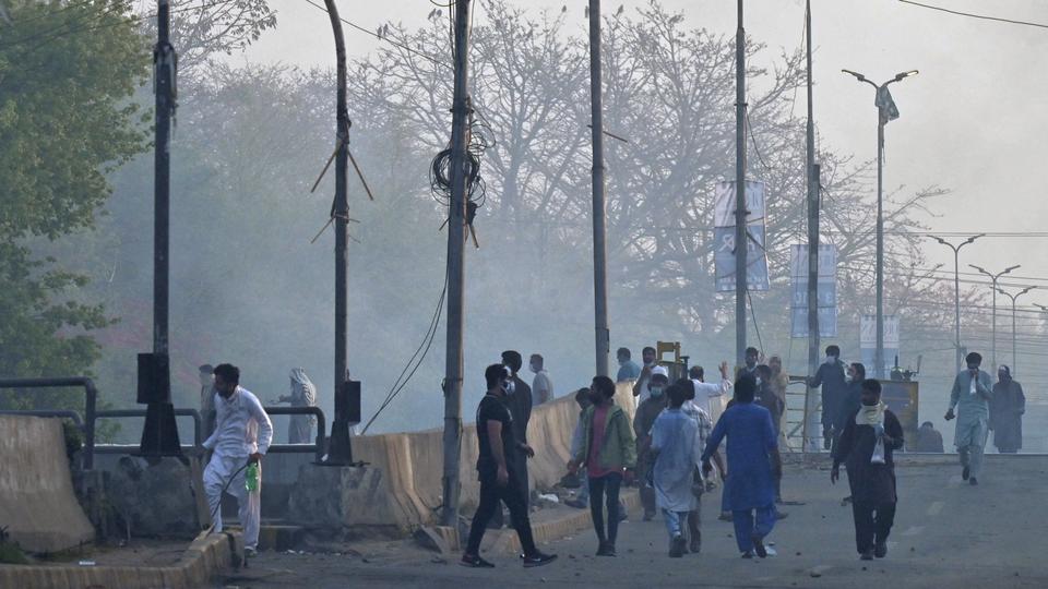 Supporters of former Pakistan prime minister Imran Khan gather along a street during a clash with police near Khan's residence, in Lahore on March 15, 2023.