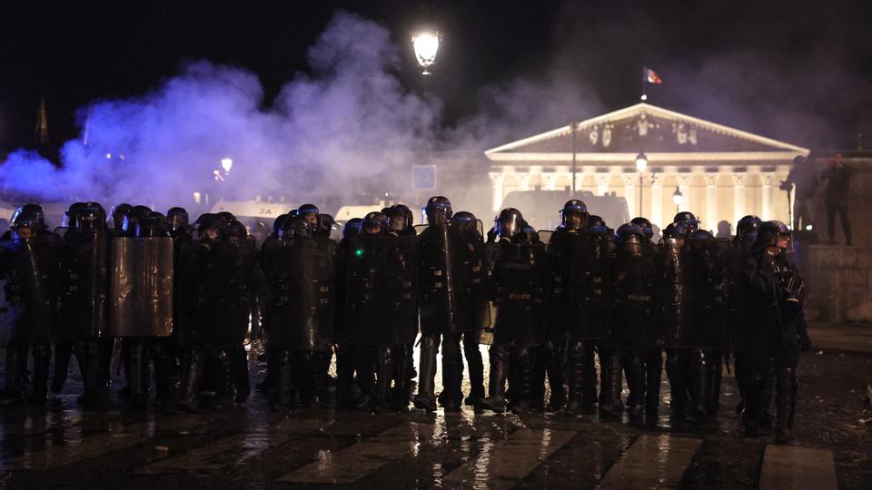 French police officers in riot gear operate during a demonstration on Place de la Concorde after the French government pushed a pensions reform through parliament without a vote.