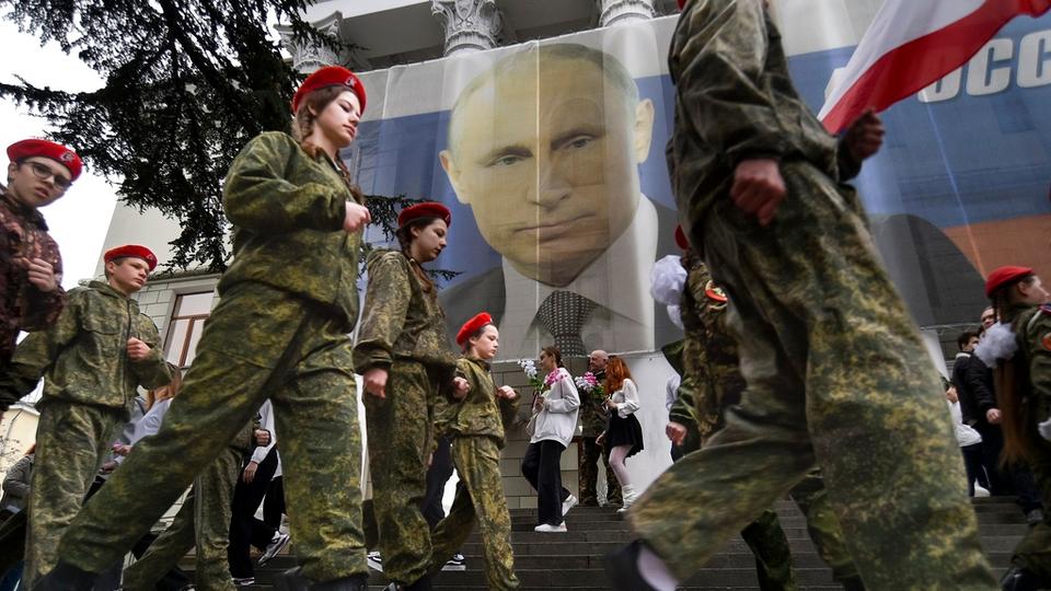 Youth take part in an action to mark the ninth anniversary of the Crimea annexation from Ukraine with the banner reading: