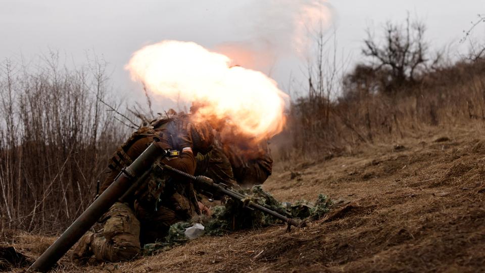 Ukrainian soldiers of the Paratroopers' of 80th brigade take cover as they fire a mortar shell at a frontline position near Bakhmut.