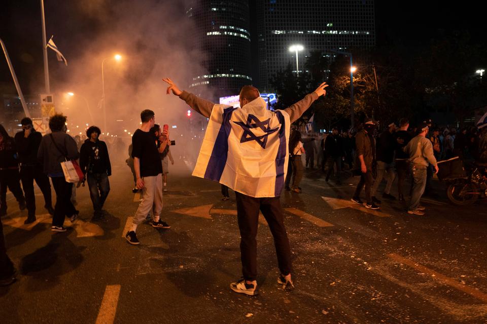 Anti government demonstrators block streets and clash with police during a protest against plans by Prime Minister Benjamin Netanyahu's government to overhaul the judicial system, in Tel Aviv, Israel, Monday, March 27, 2023.