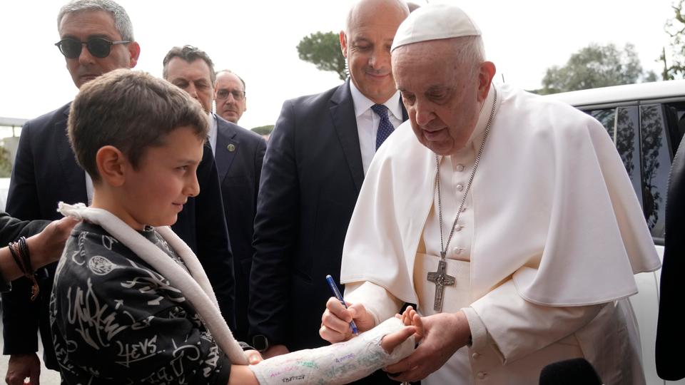 Pope Francis also signed the plaster cast of a young boy with a broken arm and waved from the window of his car as he drove away.