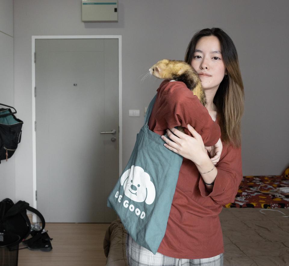 Sujitta holds her pet ferret inside her dorm room at Chulalongkorn University.