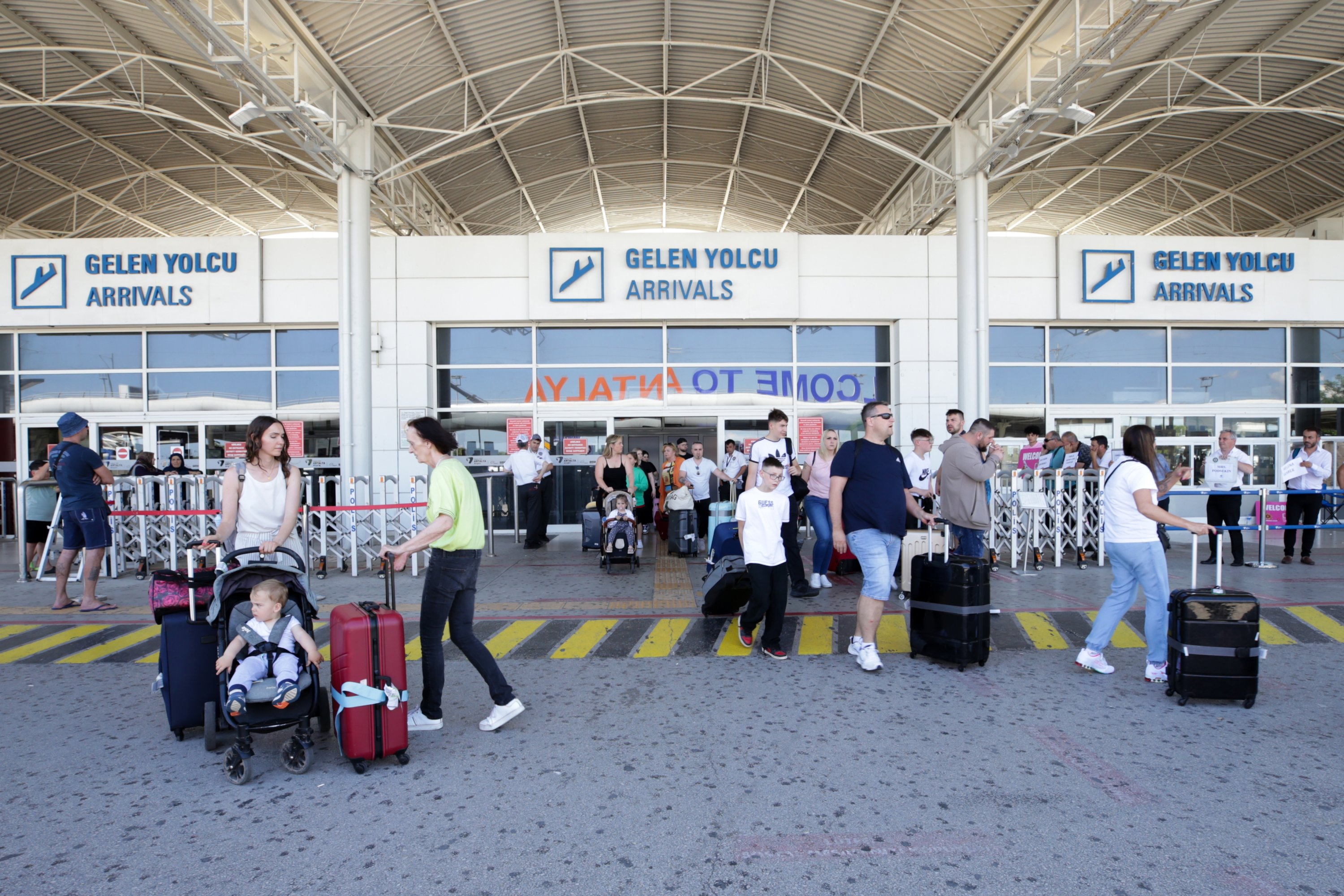281104 Tourists exit the airport as they arrive in the Mediterranean tourism hot spot Antalya, southern Türkiye, June 6, 2023. (AA Photo)
