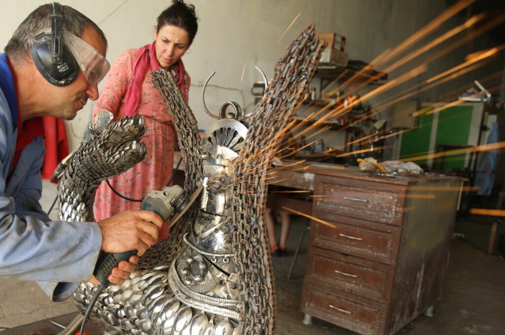 Nurettin Çakmak with his wife Agrin Çakmak makes a Shahmaran sculpture from recycled metal wastes in the Artuklu district of Mardin, Türkiye, July 10, 2023. (AA Photo)
