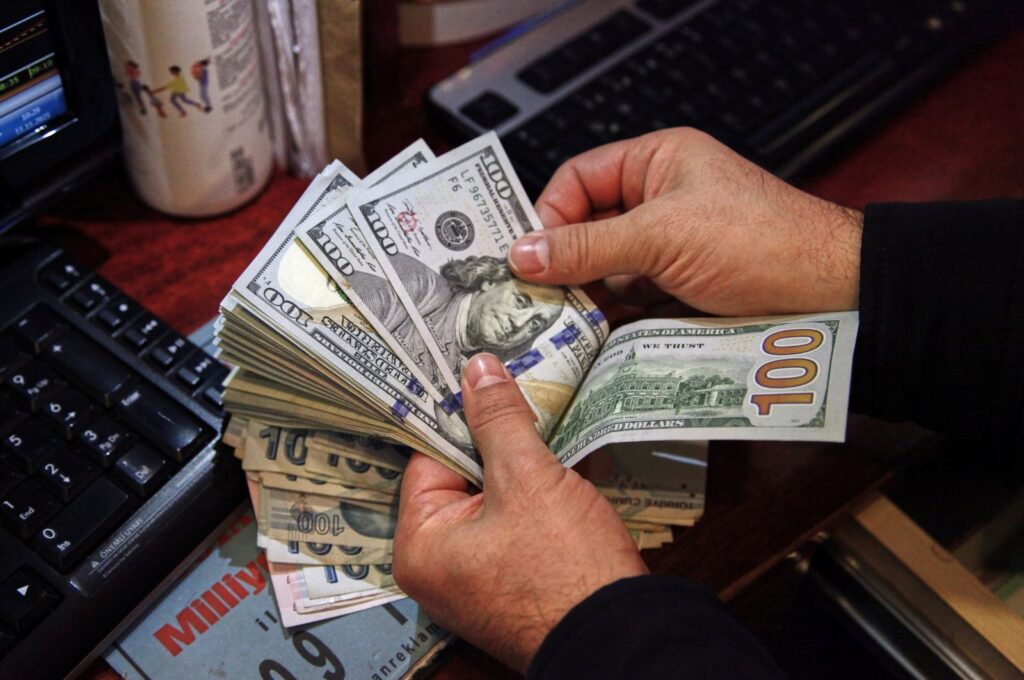 A money changer counts U.S. dollar banknotes at a currency exchange office in Ankara, Türkiye, Nov. 11, 2021. (Reuters Photo)