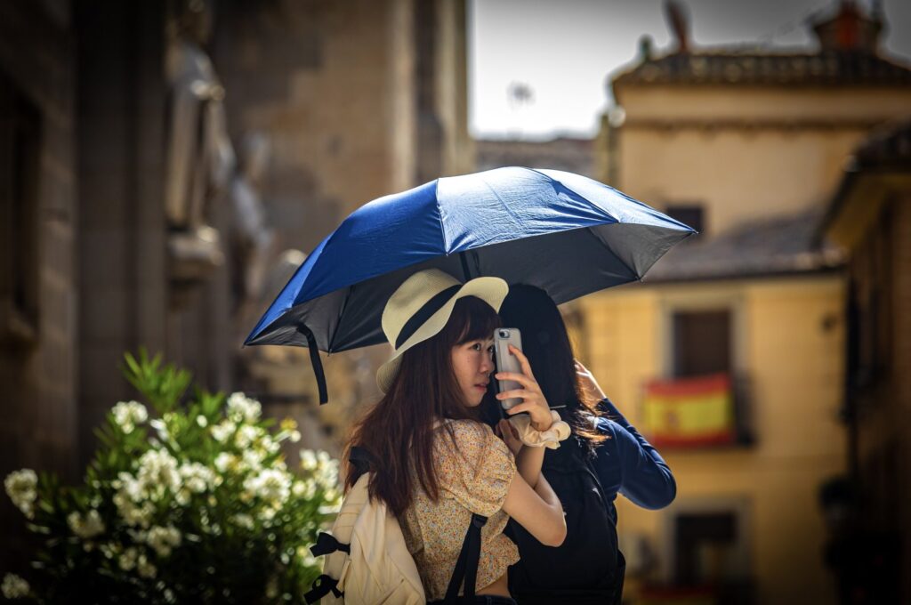 Tourists use an umbrella to protect themself from the sun in Toledo, Spain, July 17, 2023. (EPA Photo)