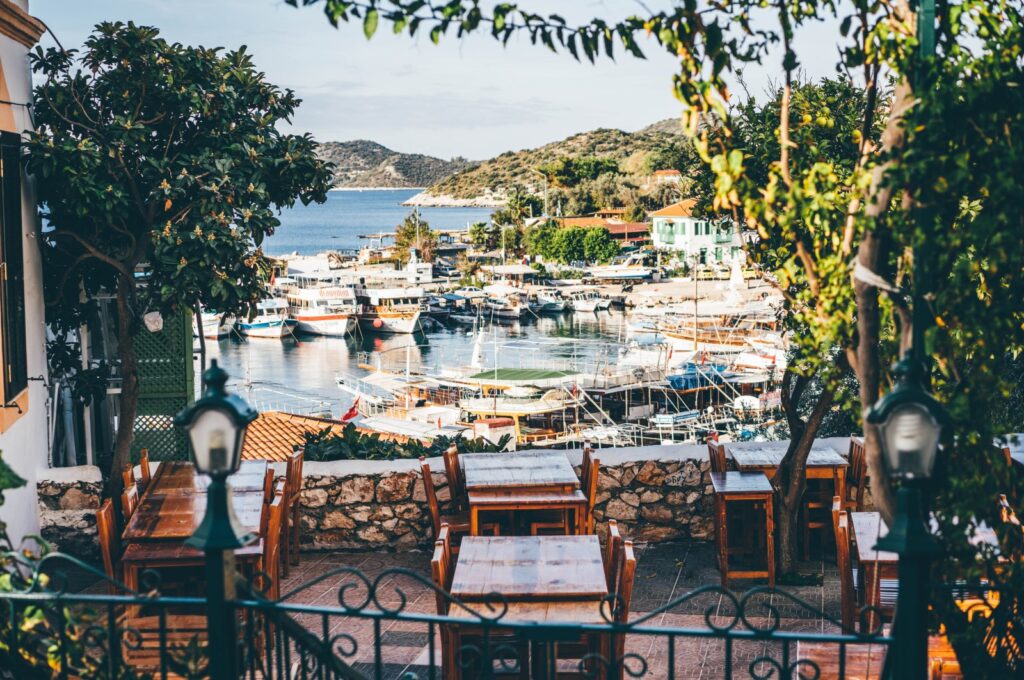 Empty street cafe with covered tables and small wooden armchairs preparing to close at end of tourist season in old Mediterranean town on a sunny day. (Getty Images Photo)