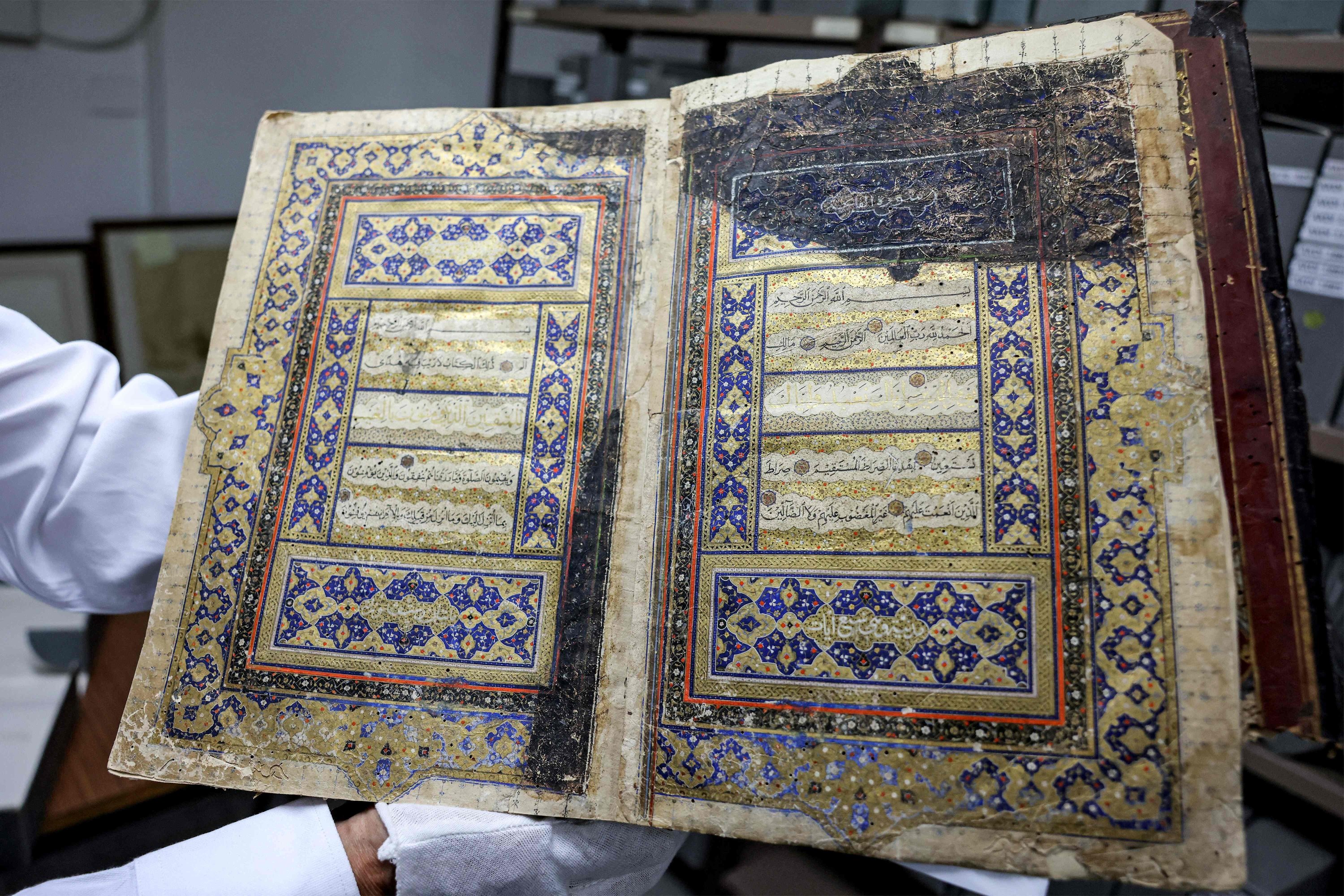 283960 Palestinian Khader Salameh, the librarian of the Khalidi Library at its headquarters located in the chain road in the old city of Jerusalem, showing a gilded copy of the Quran, Islam's holy book, which dates back to the 16th century, East Jerusalem, Palestine, June 20, 2023. (AFP)