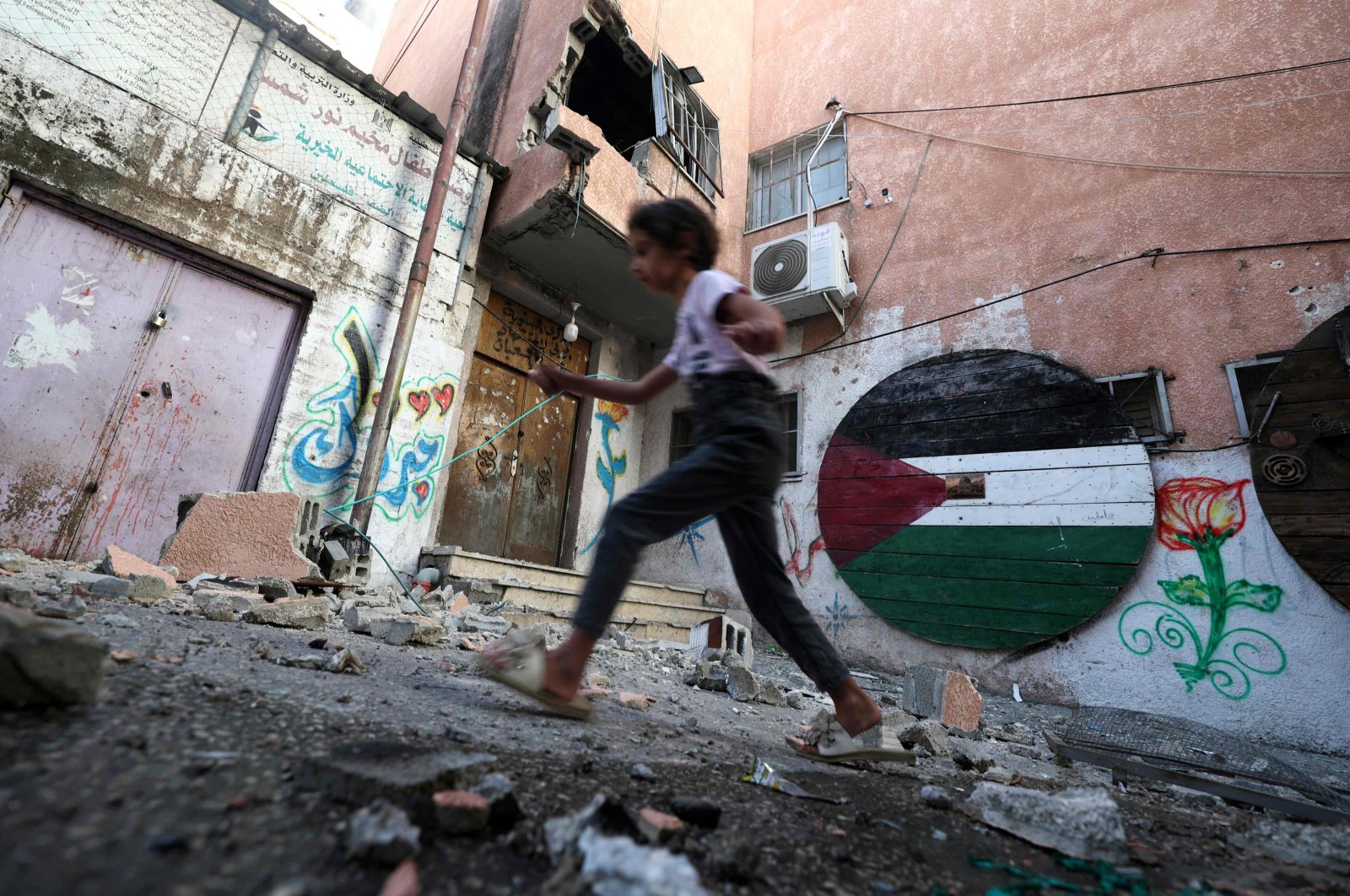 A child walks past rubble after an Israeli military raid, east of Tulkarm, in the occupied West Bank, Palestine, July 24, 2023. (AFP Photo)