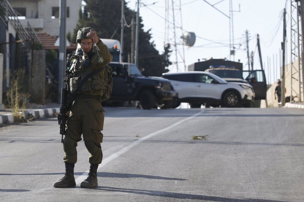 An Israeli soldier stands at the area where three Palestinians were shot dead near Nablus, occupied West Bank, Palestine, July 25, 2023. (EPA Photo)