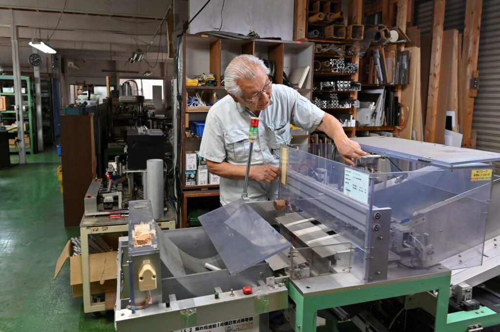 Kiyoshi Hashimoto, president of the machinery factory J&A Sakura, looking at equipment at his factory in Yachimata, Chiba prefecture, Japan, June 20, 2023. (AFP Photo)