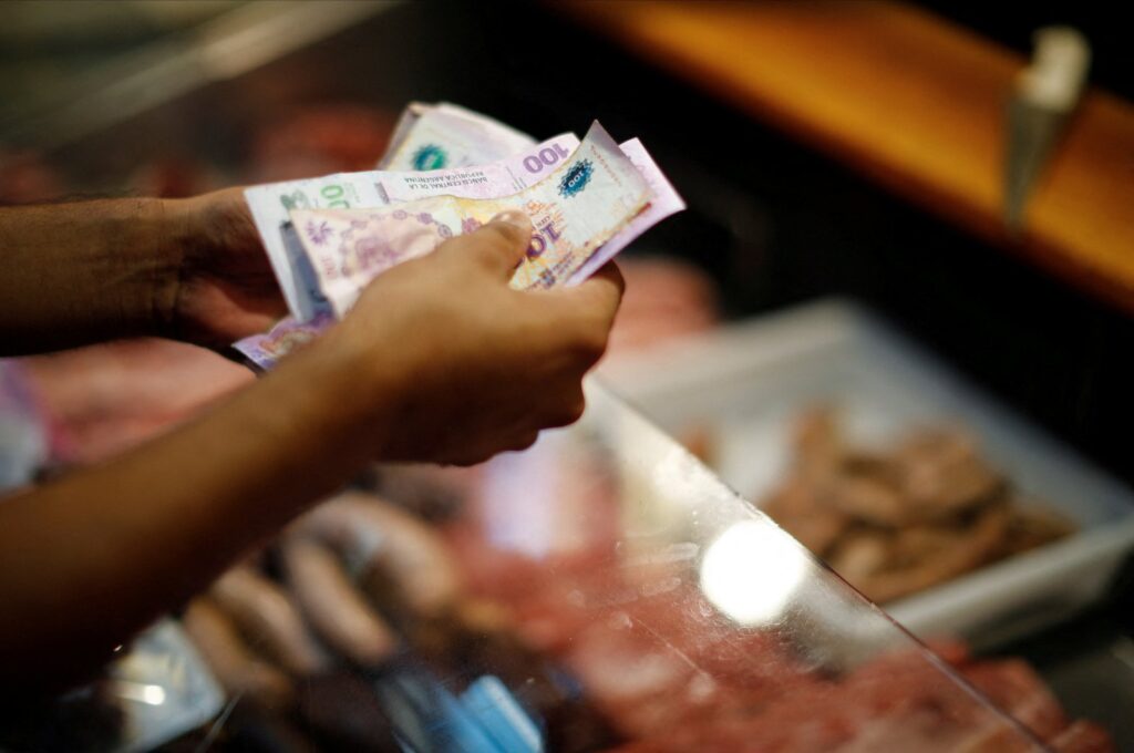 A customer pays for pork meat in a local market, as Argentina's annual inflation rate tore past 100% in February, the country's statistics agency said on Tuesday, the first time it has hit triple figures since a period of hyperinflation in 1991, over three decades ago, in Buenos Aires, Argentina, March 14, 2023. (Reuters Photo)