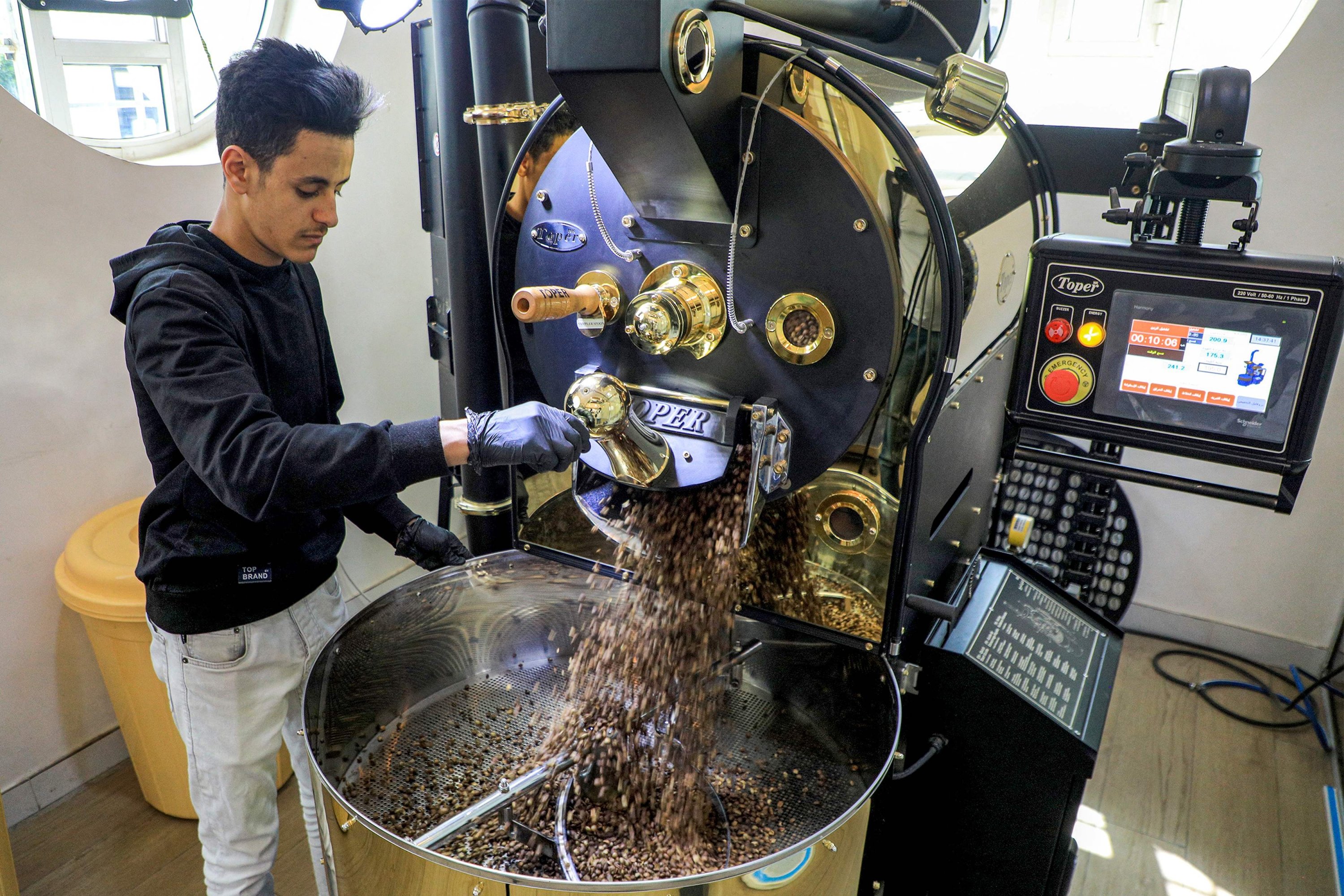 284601 A specialty coffee shop employee operates a coffee roasting machine at the shop in Sanaa, Yemen's Houthi-held capital, July 23, 2023. (AFP Photo)