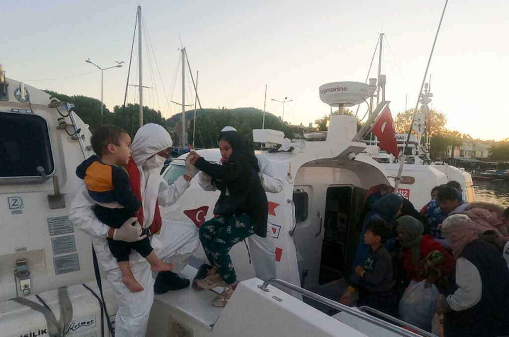 Coast guard officers escort rescued migrants to the shore, in Çanakkale, northwestern Türkiye, July 31, 2023. (AA Photo)
