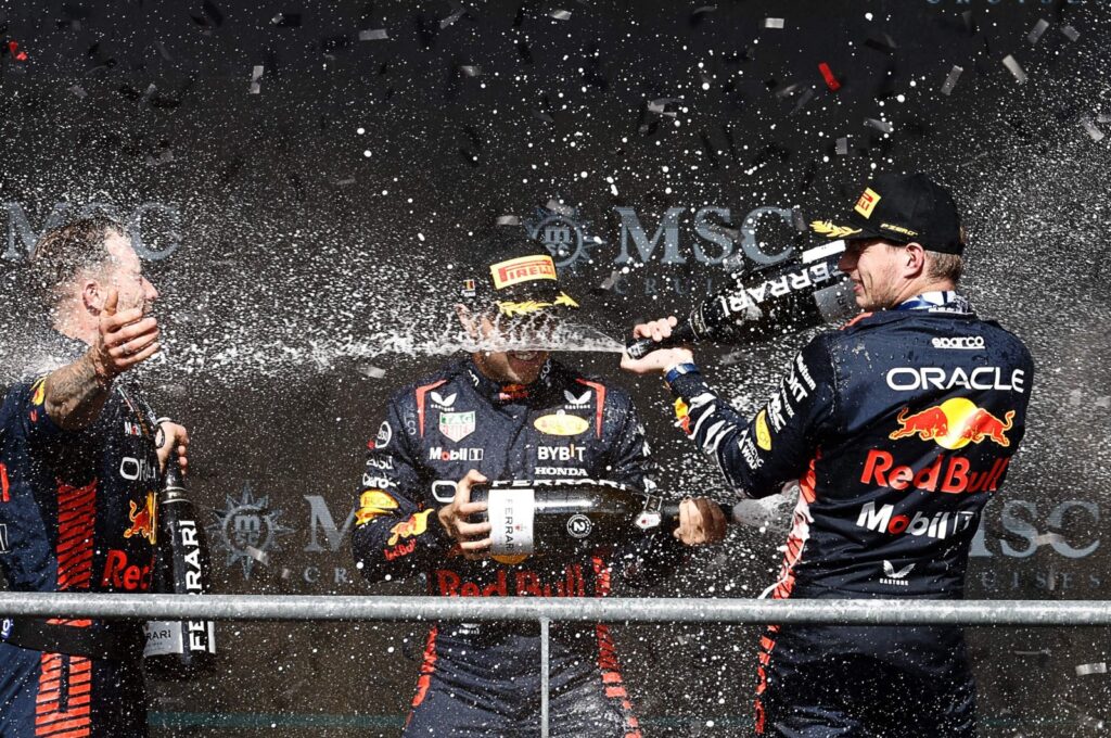 Winner Red Bull Racing's Dutch driver Max Verstappen (R) and second-placed Red Bull Racing's Mexican driver Sergio Perez (C) celebrate with a team member on the podium after the Formula One Belgian Grand Prix at the Spa-Francorchamps Circuit, Spa, Belgium, July 30, 2023. (AFP Photo)
