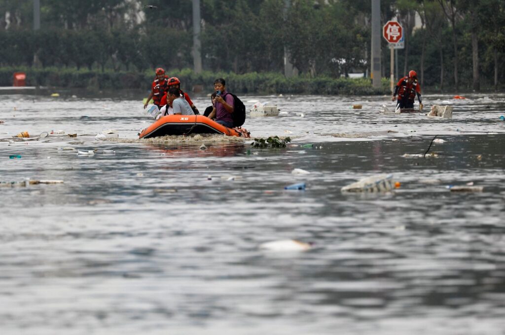 Rescue workers evacuate flood-affected residents with a boat after remnants of Typhoon Doksuri brought rains and floods in Beijing, China August 2, 2023. REUTERS/Tingshu Wang