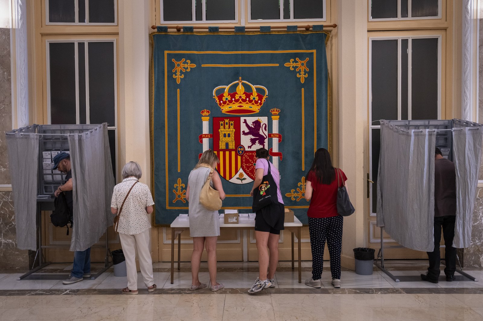 People pick their ballots before voting at a polling station for Spain's general election, in Madrid, Spain, July 23, 2023. (AP Photo)