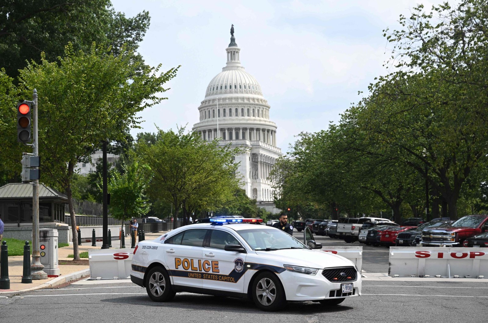 A U.S. Capitol police officer stands by his car outside the Russell Senate Office Building in Washington, D.C., on Aug. 2, 2023. (AFP Photo)