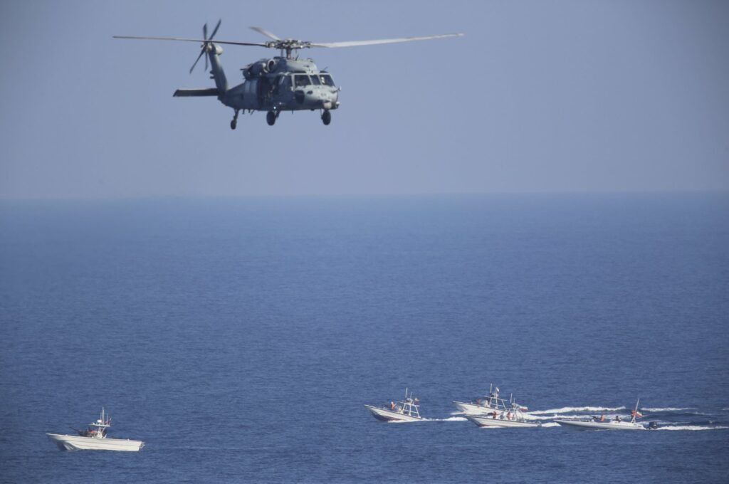 A U.S. MH-60 Seahawk helicopter flies over Iranian Revolutionary Guard patrol boats in the Strait of Hormuz, Dec. 21, 2018. (AP File Photo)