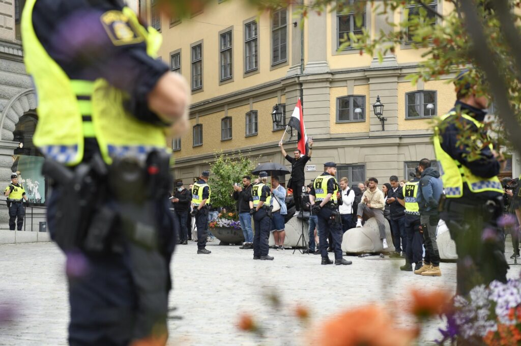 Police stand guard as a man (not in the picture) prepares to burn a copy of the Quran in Stockholm, Sweden, July 31, 2023. (EPA Photo)